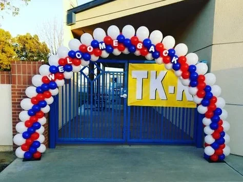 Welcome back to school balloon arch in red, blue, and white, adorned with beautiful balloons.