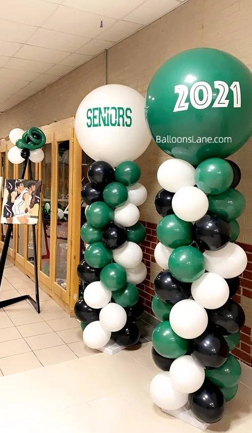 Large custom balloons in a color palette of green, white, and black, arranged in a stylish column for a striking visual display.