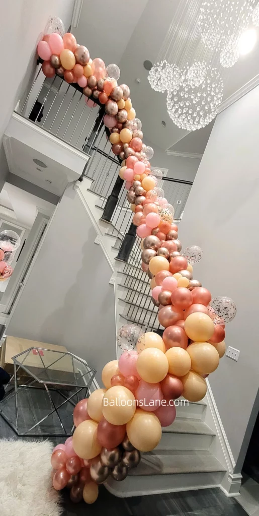 Balloon garland stairs arch featuring pink, peach, confetti and gold latex balloons in New Jersey.