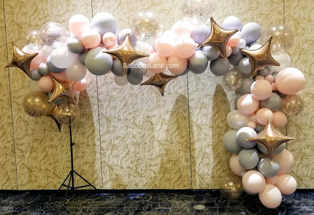 A vibrant balloon garland in pink, grey, confetti gold and gold star foil balloons, perfect for celebrations on Staten Island