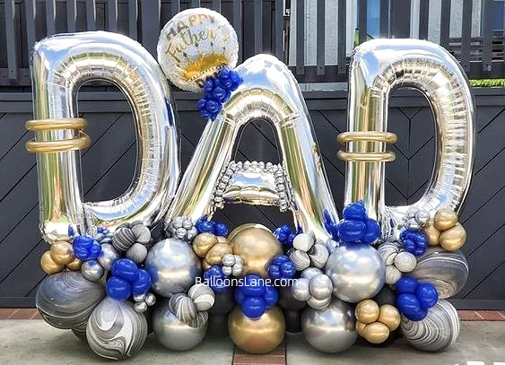 Fathers Day balloon arrangement featuring DAD letter balloons with a backdrop of chrome silver, gold, blue, and zebra-print balloons in Manhattan