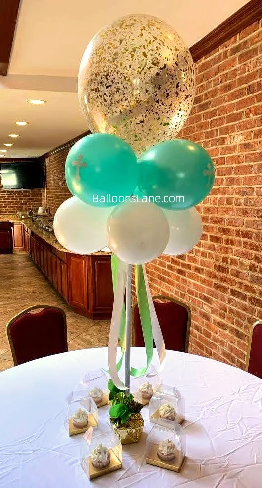 A bouquet featuring a large gold confetti balloon and sea green christening balloons, arranged to celebrate a christening in NYC