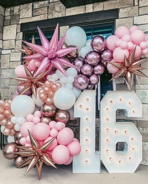 A festive balloon bouquet of pink, rose gold and white latex balloons, accompanied by a Star Mylar balloon