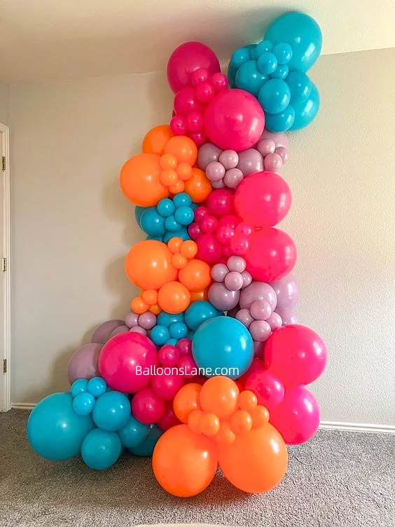 Vibrant balloon garland in orange, purple, blue, and wild Berry, featuring balloons of various sizes for diverse celebrations.