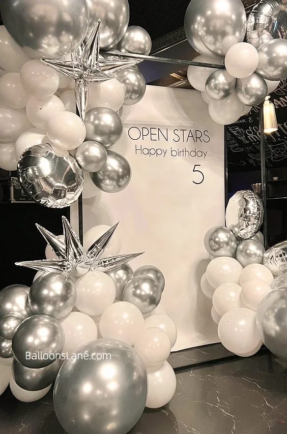 Shimmering Chrome® Silver balloon ensemble in various sizes, accented with foil stars and round balloons, along with white latex balloons, perfect for magical movie nights, night outs, and more in Brooklyn.