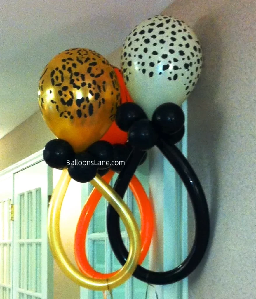 Twisted balloons in black, gold, and orange, along with white, orange, and gold printed balloons for all events in NYC