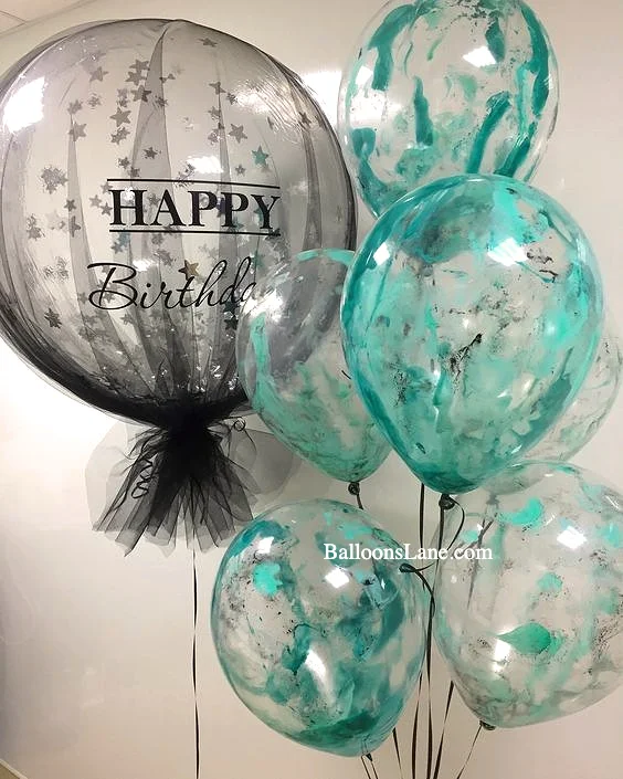 A birthday balloon featuring a 'Happy Birthday' message in sea green and black colors, covered with red and green paint, perfect for celebrations in NYC