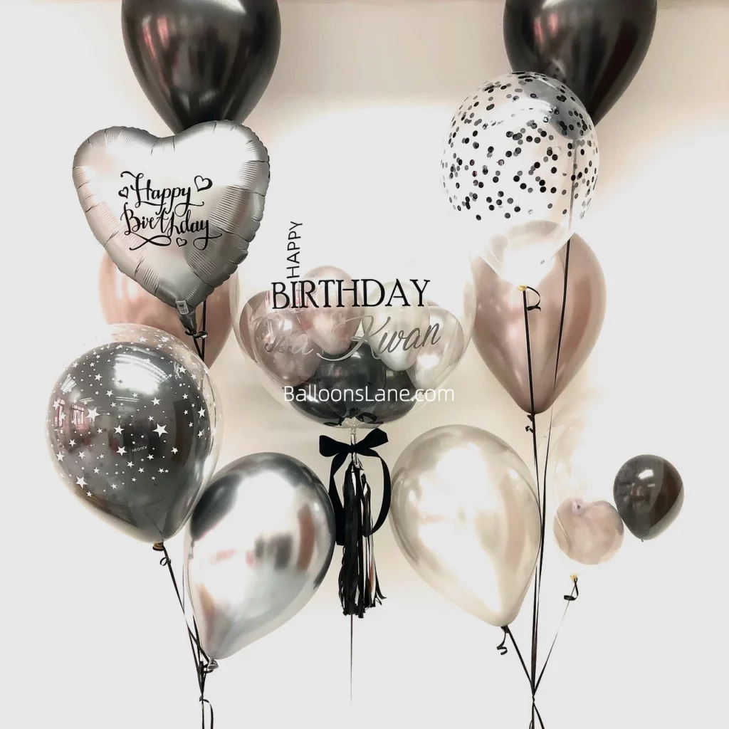 A personalized birthday balloon bouquet featuring black, silver, rose gold, and black confetti balloons, perfect for celebrations in New York City.
