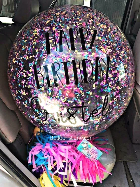 Jumbo multicolor confetti balloons with colorful streamers and pompoms to celebrate a birthday party