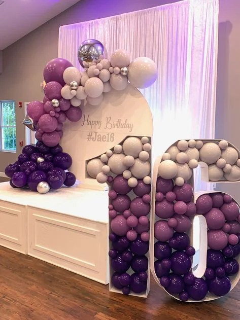 A half arch of multiple-sized balloons in shades of purple and white, creating a stunning display for a 16th birthday celebration in New York