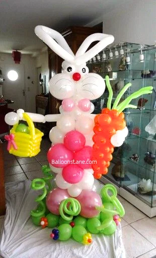 A vibrant Easter Bunny balloon sculpture created from twisted balloons in shades of green, white, yellow, and pink, displayed in Brooklyn.