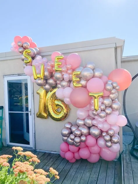 A backdrop arrangement featuring "SWEET" letter balloons, a number 16 balloon, and multiple-sized balloons in pink, candy pink, and rose gold, in Manhattan