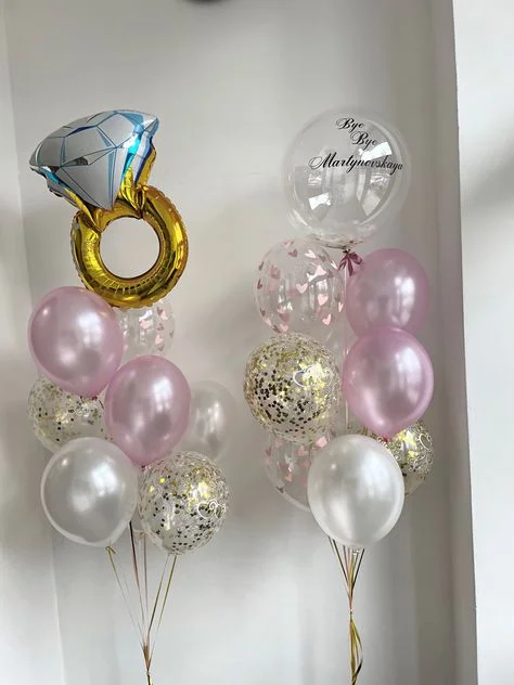 A bouquet featuring a customized gold balloon with clear balloons, pink, white, and gold confetti balloons in NYC