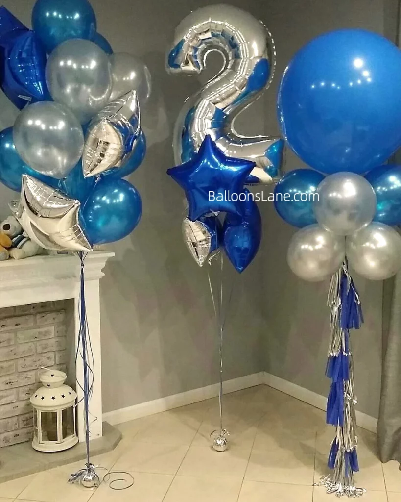 A delightful bouquet featuring silver number "2" mylar balloons surrounded by blue latex balloons and accented with a large blue star balloon and a big round blue balloon.