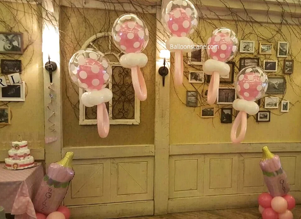 Foil balloons featuring "Baby It's a Girl" and a lollipop design in pink to announce your baby's gender in NJ