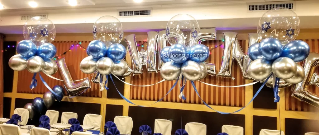 Customized chrome silver and blue latex balloons arranged in a table arch with a Star of David, personalized for a boys' bar mitzvah celebration in Staten Island.